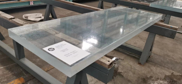 Thick transparent acrylic pool panel on a fabrication workbench